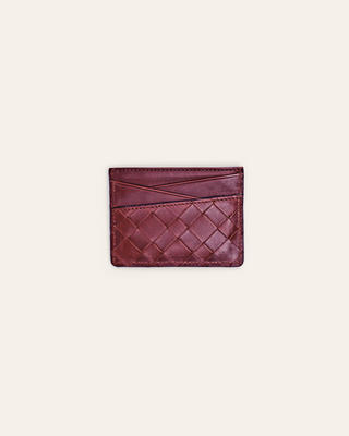 Burgundy woven leather cardholder on a light beige background