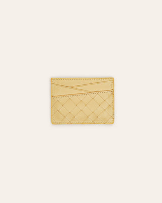 Yellow woven leather cardholder on a light beige background