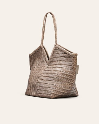 Cala Jade grey woven shoulder bag seen from the side on a beige background