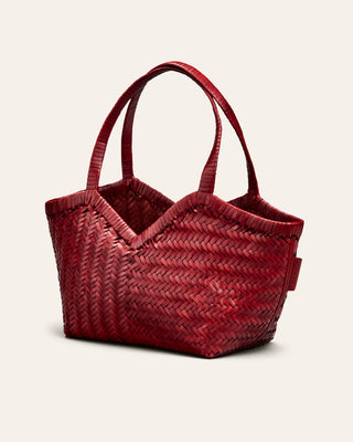 Cala Jade Red woven handbag on a light beige background seen from the side
