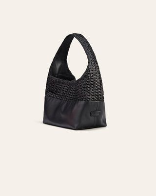 Cala Jade Iak mini Black leather bag seen from the side on a beige background