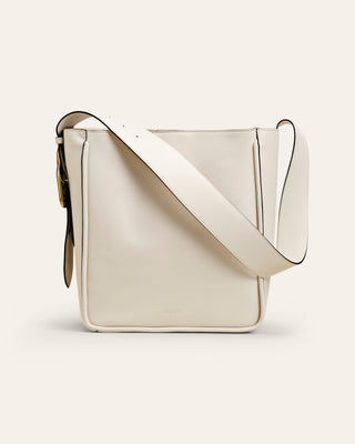 White leather shoulder bag on beige background