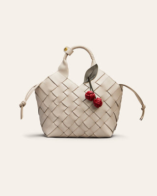 Cala Jade Misu medium in white with a red cherry bag charm on a beige background