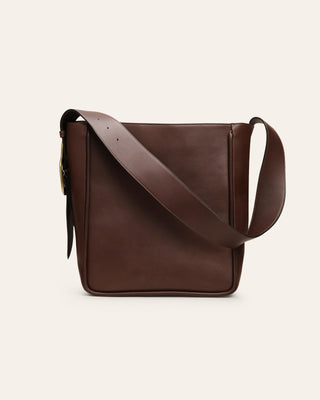 Brown leather shoulder bag on a beige background