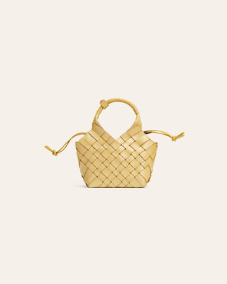 Cala Jade Small woven yellow handbag on a light beige background