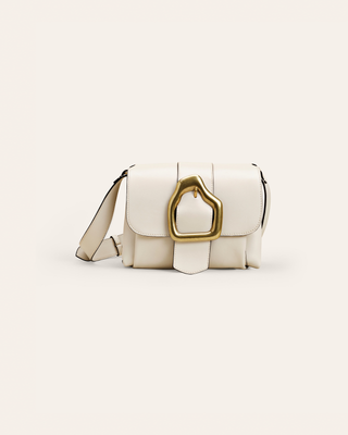 White leather handbag with a gold buckle on a light beige background