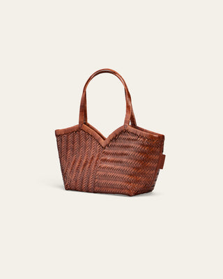 Cala Jade brown woven leather bag on a beige background seen from the side