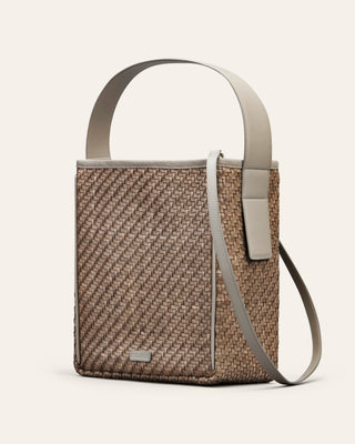 Cala Jade Iwa woven handbag with a strap and handle on a light gray background seen from the side