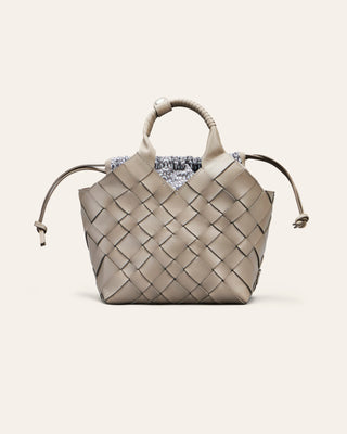 Cala Jade Woven beige handbag on a light beige background with a cotton drawstring bag inside