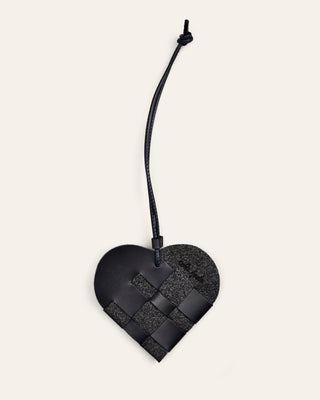 Cala Jade Black woven heart-shaped bag charm on a beige background