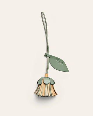 A flower shaped leather bag charm in yellow and green 