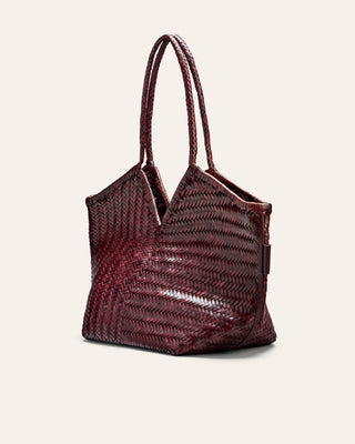 Woven leather handbag with a woven pattern on a light beige background