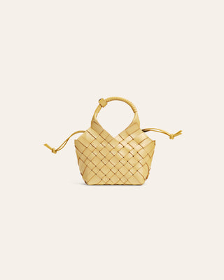 Cala Jade Small woven yellow handbag on a light beige background
