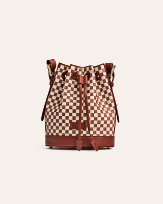 Checkered bucket bag with brown leather accents on a white background